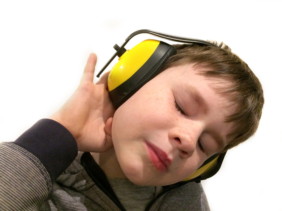 Autistic child with ear defenders